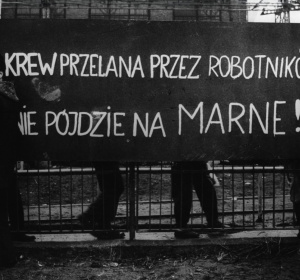 Zdjęcie z transparentem na parkanie "Krew przelana przez robotników nie pójdzie na marne!"