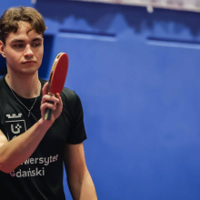 Uczestnik podczas meczu, z paletką, po odbiciu piłeczki