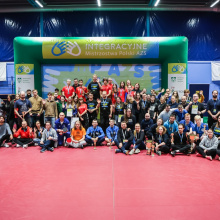 Duże zdjęcie grupowe uczestników IMP pod bramką z logo IMP