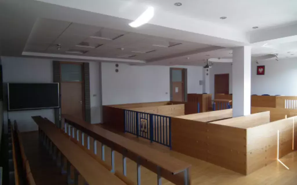 Sala rozpraw - widok od strony okna w kierunku ławy sędziowskiej.