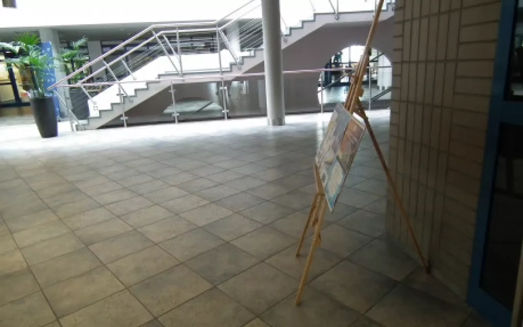 widok na fragment holu na 1 piętrze Wydziału Prawa i Administracji. Po prawej widać stojący stand na plakaty