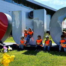 Przedszkolaki poznają okolice UG Przedszkolaki poznają okolice UG, na zdjęciu grupa dzieci siedzi na napisie "I love UG"